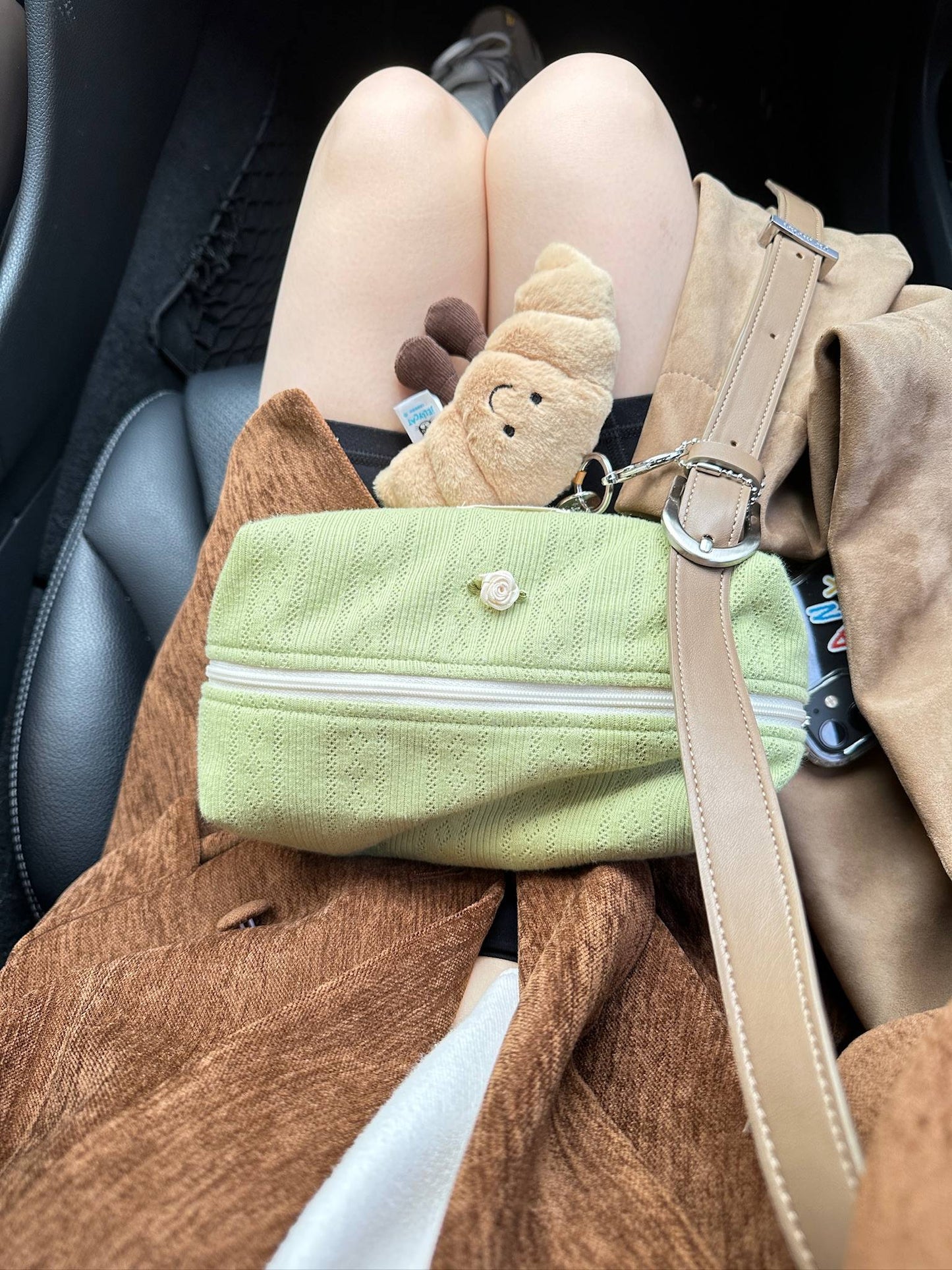 귀여운 인형 키링과 함께 무릎 위에 놓인 마차라떼 파우치가 가을 감성을 완성해줘요.