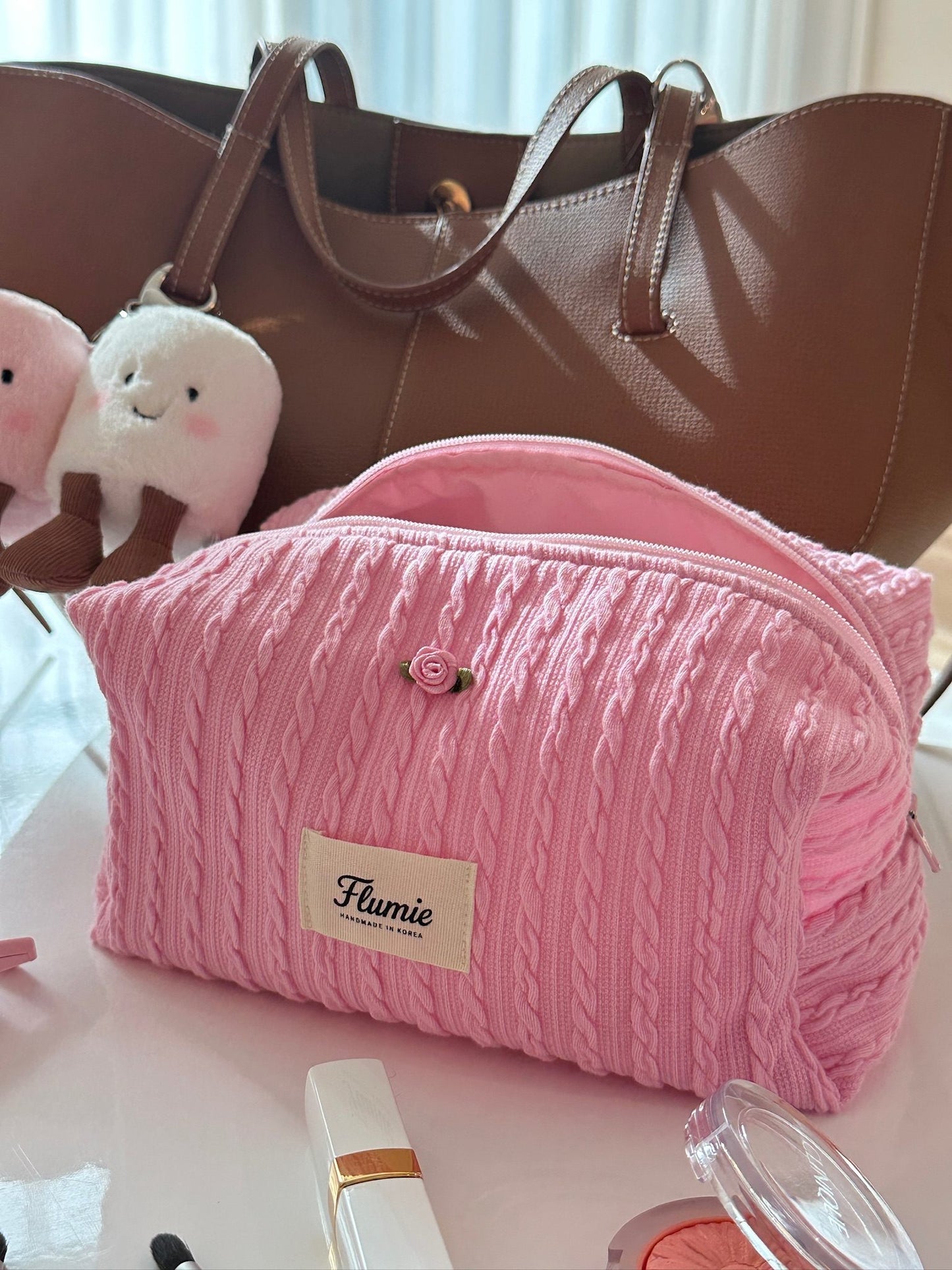 딸기우유 컬러의 케이블 니트 파우치가 포근하고 사랑스러운 분위기를 자아내요.