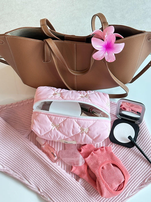 핑크 리본퍼프 파우치가 가방과 함께 놓인 데일리 외출룩 컷