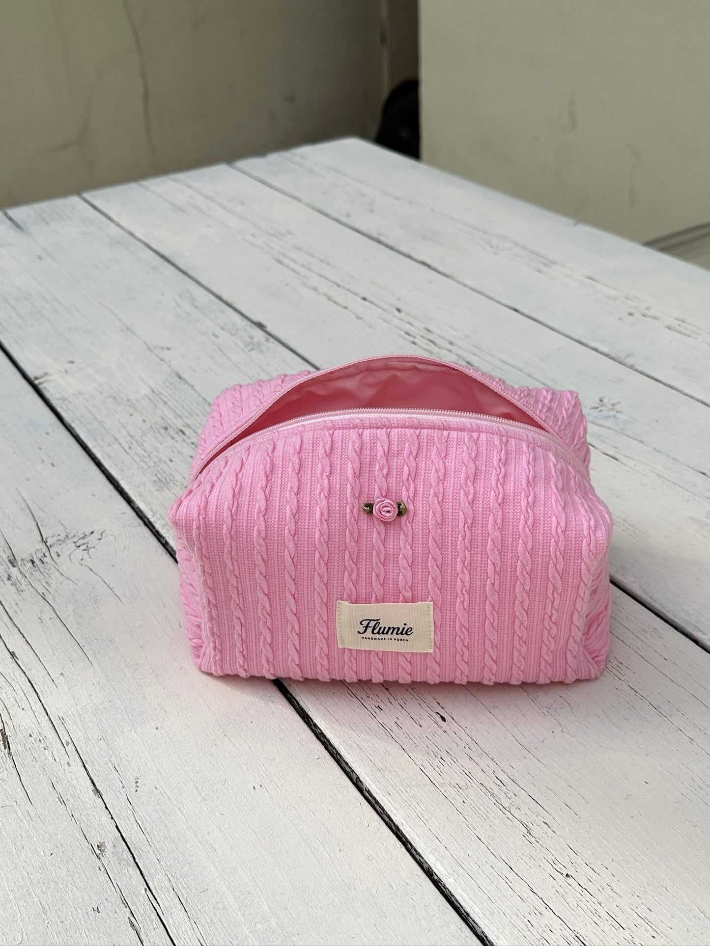 딸기우유 컬러의 케이블 니트 파우치가 포근하고 사랑스러운 분위기를 자아내요.